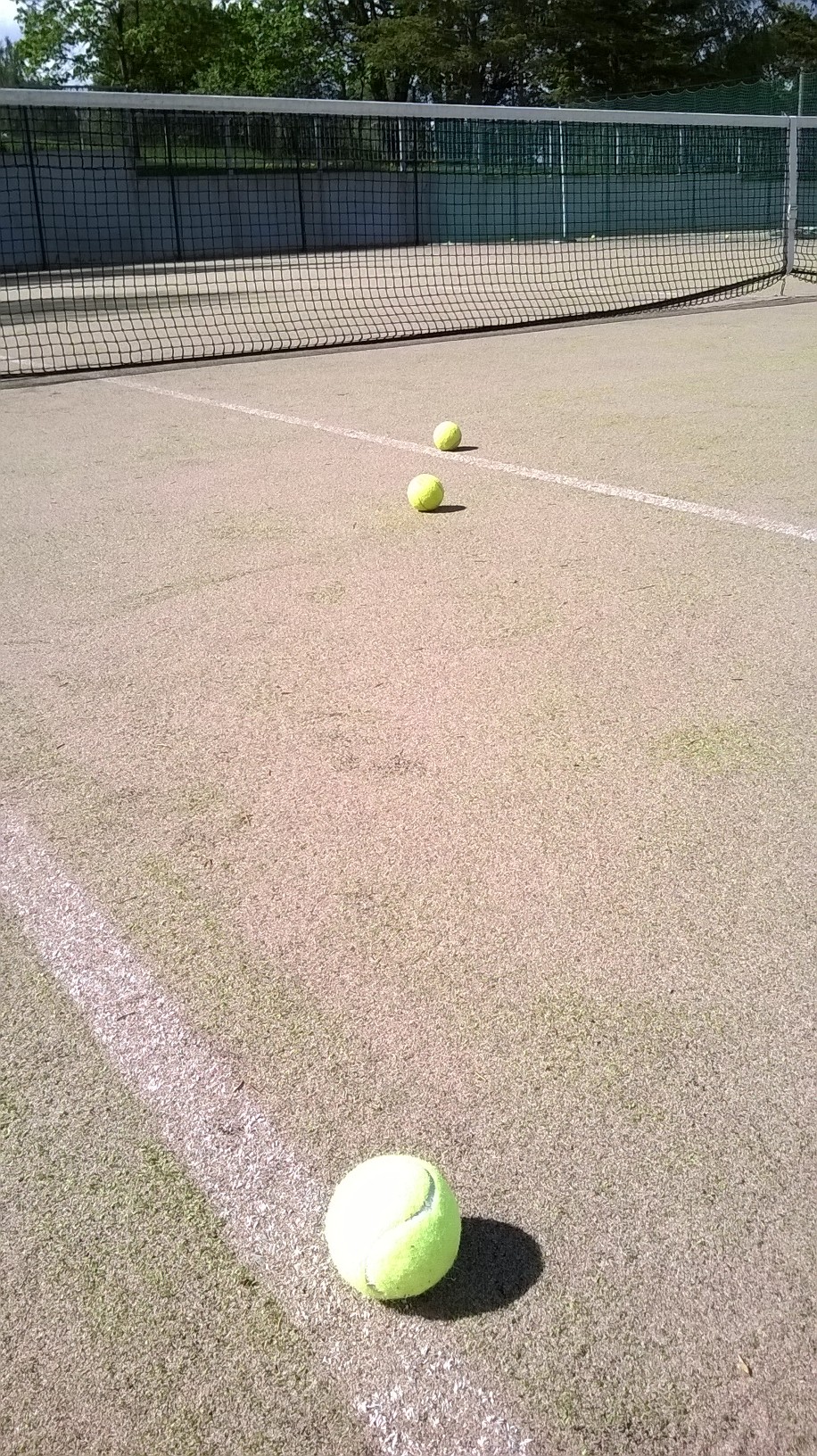 Tenniskenttä ja tennispallot rivissä